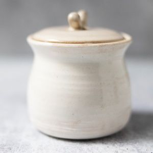 Signed cream pottery canister jar with lid 3 inches tall 3.25 inches wide